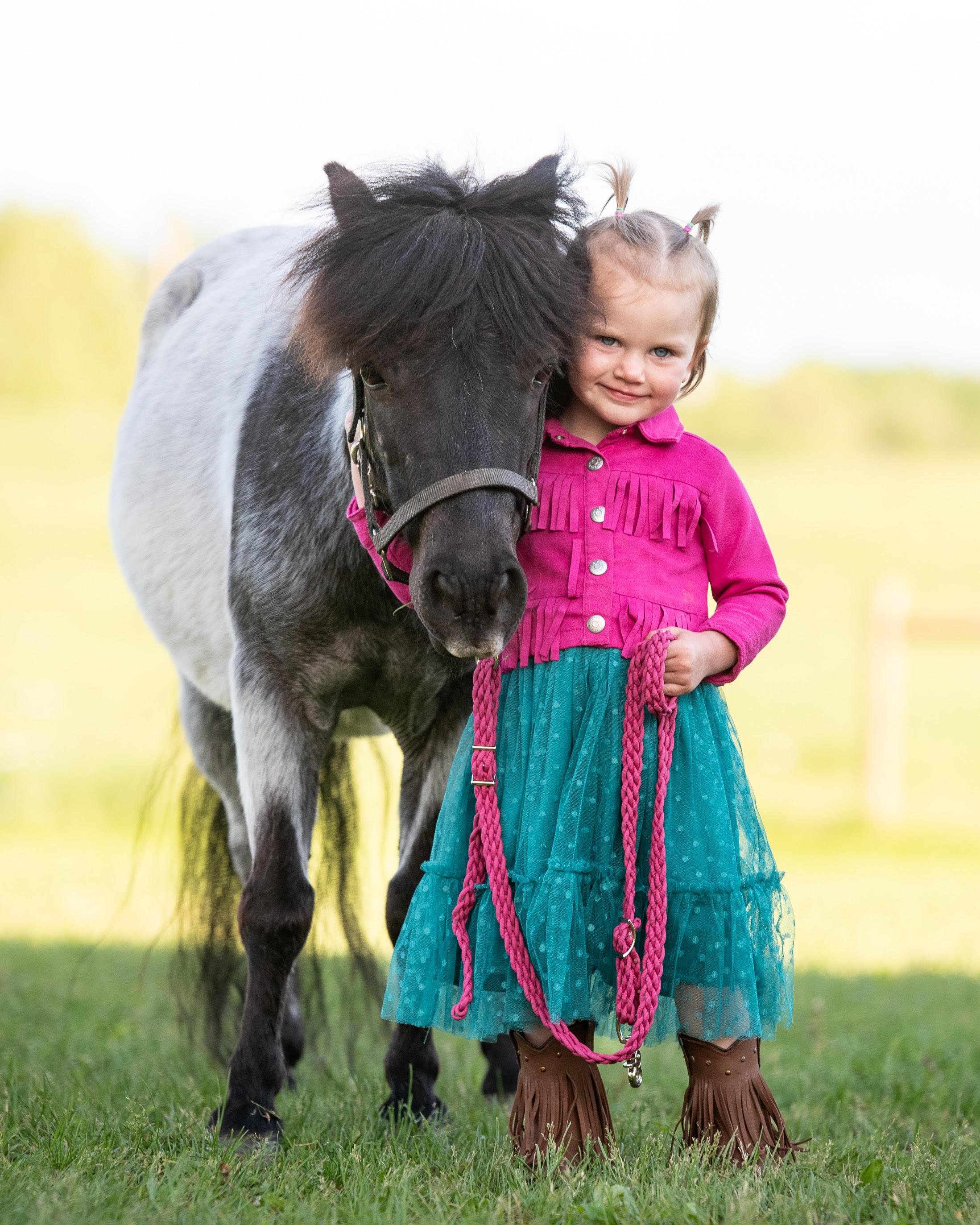 A young girl hugging a pony at a Pony Parties Express event